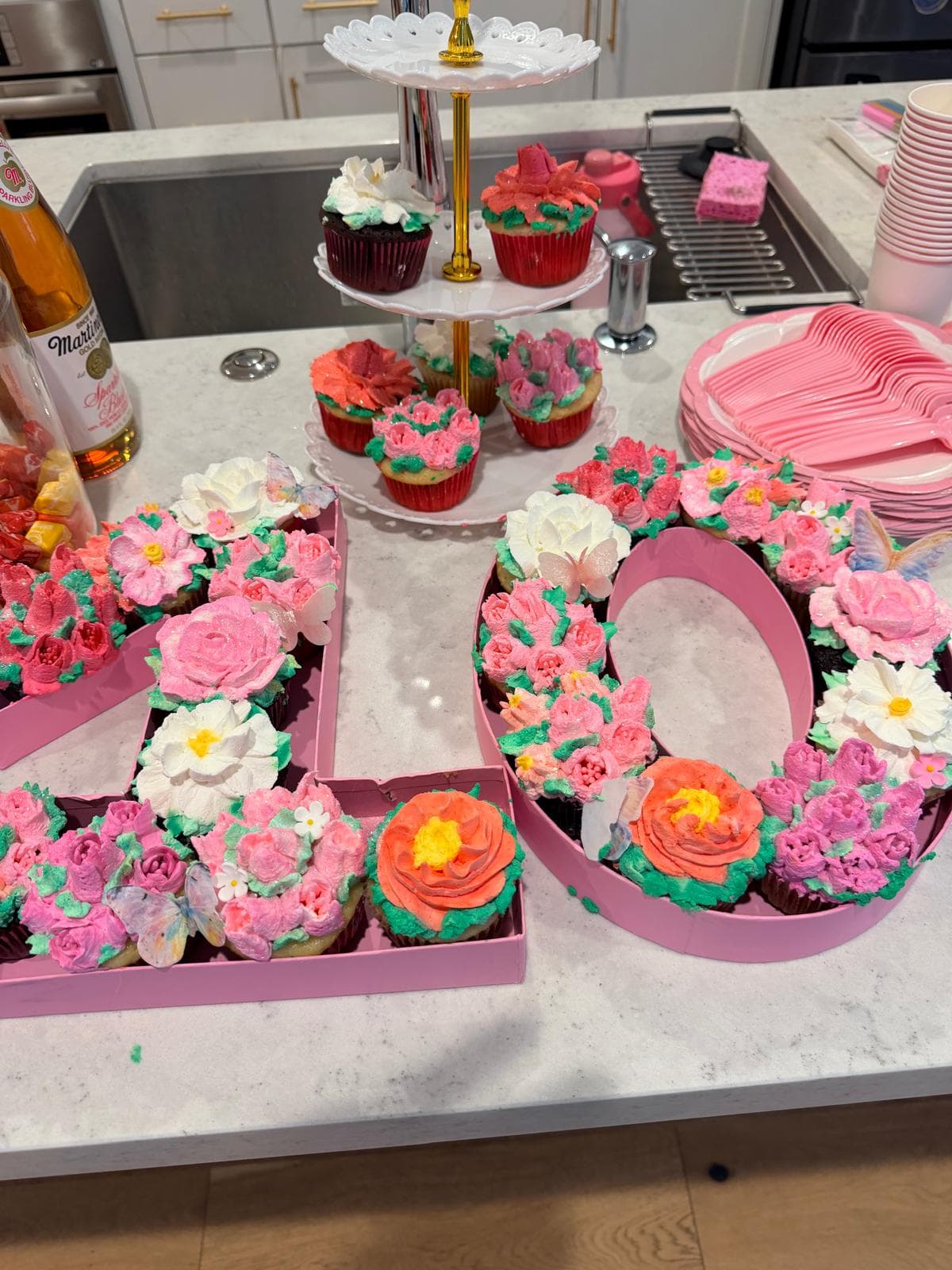 Cupcakes arranged as the number ten, decorated with pink and coral frosting flowers